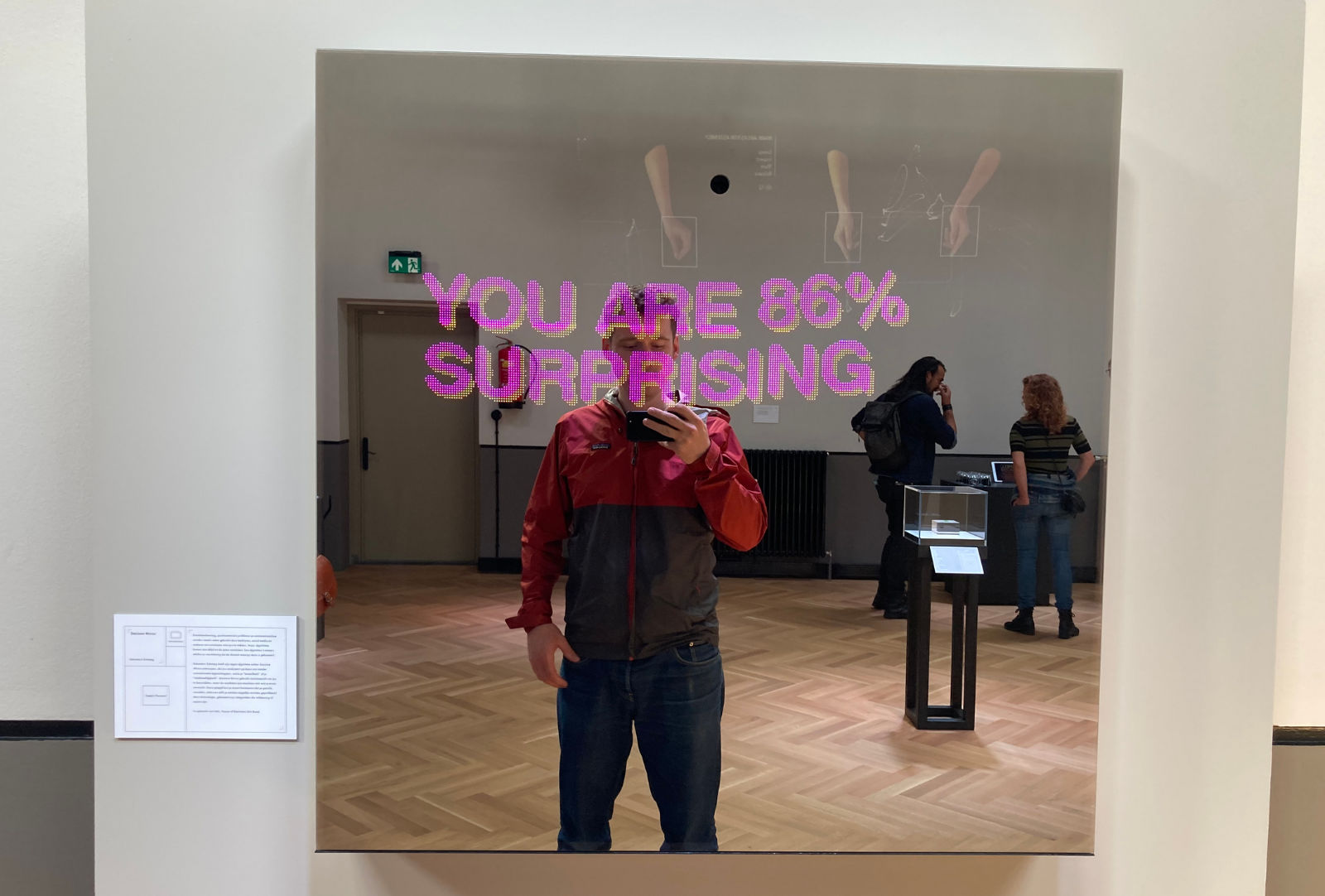 person in front of mirror that says in large pink letters 'you are 86 percent surprising'